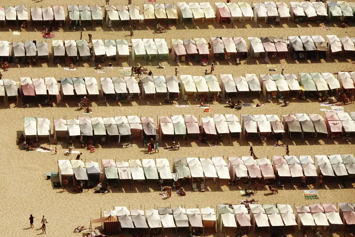 Spiaggia affollata con ombrelloni disposti ordinatamente sulla sabbia