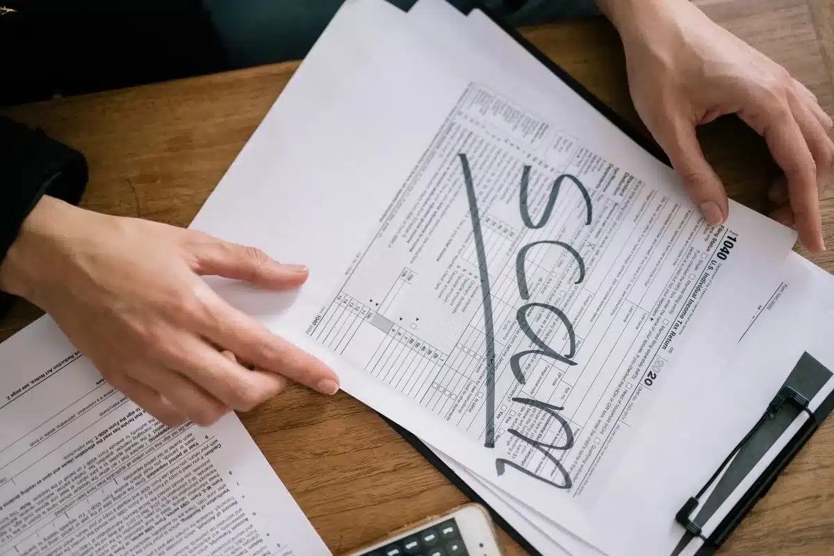 Documenti di identità contraffatti e originali confrontati su una scrivania investigativa