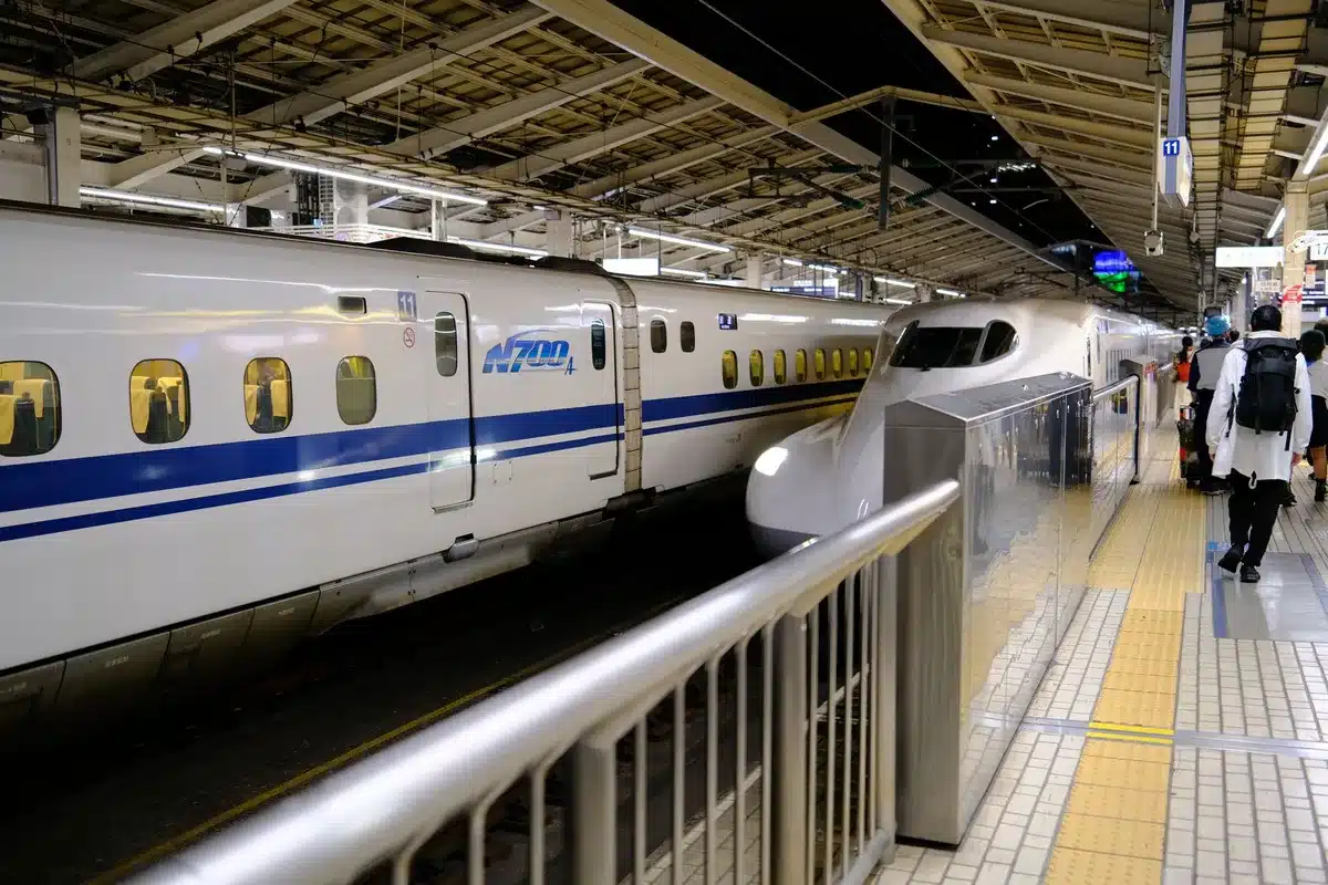 Passeggeri che salgono su un treno moderno e puntuale in una stazione giapponese